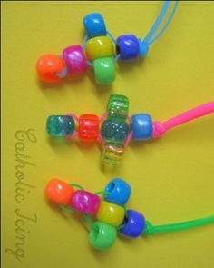 three colorful beaded necklaces sitting on top of a yellow surface