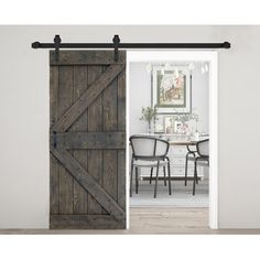 an open barn door with two chairs and a table in front of the sliding door