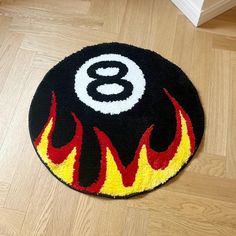 a round rug with the number eight on it in flames and red, yellow, and black colors