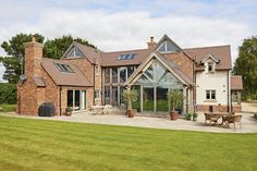 a large brick house sitting on top of a lush green field