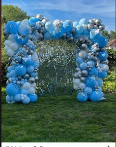 an arch made out of blue and silver balloons