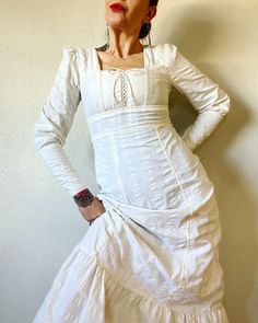 "Corset Cutie. Beautiful Vintage 1970's ivory seersucker stripe corset prairie maxi with zip cuff leg of mutton sleeved, tie back waist, cotton lace trim and ruffle hem by Joni Blair. Definitely a Camila vibe, and just a classic romantic beauty.  🕊️🕊️🕊️ Marked a vintage size 11 Fits S/M (I'm about a M), but please use measurements as fit guide. 14.25\" shoulder  17.75\" bust, up to 19\" if laces are loosened (on the half)  15\" waist (untied, on the half)  21\" hip (on the half)  25\" sleeve  57.25\" length  Unlined  65/35 cotton/poly wide seersucker stripe  Center back Talon zipper closure  Corset lace bust  Gathered shoulder caps  Leg of mutton sleeves with zipper cuffs  Cotton lace trim throughout  Attached tie back waist  Princess seams  Ruffle hem  No brand label, but rn tag tracks Fitted Victorian Cotton Prairie Dress, Fitted Prairie Dress With Puff Sleeves And Ruffles, Fitted Prairie Dress With Ruffles And Puff Sleeves, Daywear Prairie Dress With Ruffled Fitted Bodice, Fitted Long Sleeve Prairie Dress With Gathered Sleeves, Fitted Long Sleeve Cotton Prairie Dress, Fitted Cotton Prairie Dress For Daywear, Fitted Peasant Prairie Dress, Fitted Cream Prairie Dress