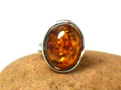 A smart large cognac Amber ring set in a stylish Sterling Silver design and gift boxed.  Size of Amber: 14 x 19 mm. Weight - 8.6 g. Amber is technically not a gemstone or mineral, but a fossilised sap from prehistoric trees that has aged over the course of millions of years. Amber is usually thought of as yellow golden in hue, but amber also can be found in shades of milky white, red-orange, green, black and even (very rarely) violet. Early physicians prescribed amber for headaches, heart proble Classic Amber Rings For Gifts, Formal Amber Oval Cabochon Rings, Modern Brown Rings For Gifts, Modern Brown Rings For Gift, Brown Polished Finish Ring As Gift, Brown Ring With Polished Finish For Gift, Formal Brown Cabochon Rings, Formal Brown Rings With Polished Finish, Brown Rings With Polished Finish For Gift