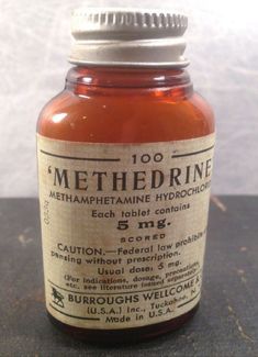 an old medicine bottle sitting on top of a table