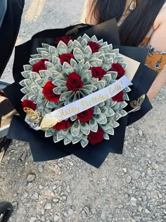 a woman holding a bouquet of roses and money wrapped in paper with the words happy birthday lily on it