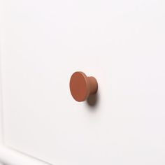 a white cabinet with a brown knob on it