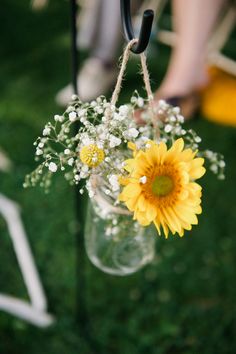 a mason jar with flowers hanging from it