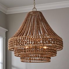 a chandelier made out of wooden beads hanging from a ceiling in a room