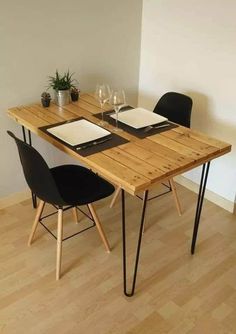 a wooden table with two black chairs next to it