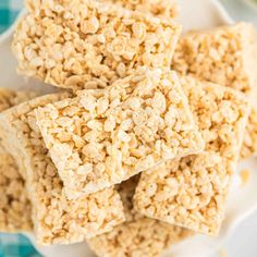 rice krispy treats stacked on top of each other in a white plate with blue and green napkins