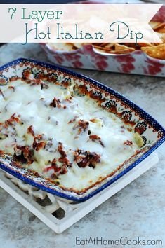 a casserole dish with meat and cheese in it, next to a box of baked potato chips