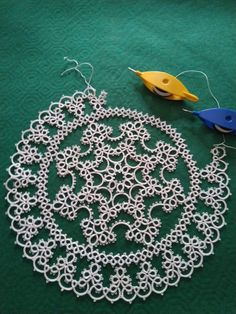 a crocheted doily with scissors and thread