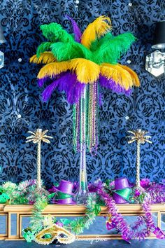 a table topped with purple, green and yellow decorations on top of a blue wall