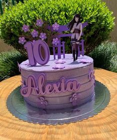 a purple cake with the word alesia on it and a girl standing on top