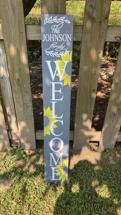 a welcome sign in front of a wooden fence with the word welcome painted on it