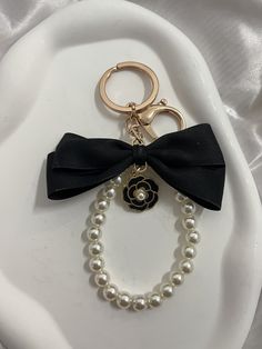 a white plate topped with a black bow and pearls