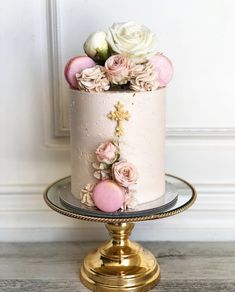 a white cake with pink flowers and gold lettering that says new grace on top, sitting on a pedestal