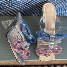 Absolutely Authentic, Guaranteed! Gorgeous Mach & Mach Triple Bow Strass Heeled Sandals, Size 39. Pink, Blue, And Silver Bows On Front, Silver And Nude Leather Footbed. Has Been Worn Twice Only! Light Scratches To Bottom Soles, Marks On Heels And Toe Corner/Edges, And Soiling/Marks On Footbed. Originally $1200 Usd After Tax! Ready To Ship! Bow Sandals, Silver Bow, Clear Heels, Heeled Sandals, Blue And Silver, Shoes Women Heels, Pink Blue, Sandals Heels, Shoes Heels