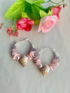 Crystal hoops  and Pearl hoops that are Beach themed.  These hoops are secured onto a silver plated hoop measuring around 3cm. The earrings are decorated with  tiny faux 3mm pearls,  salmon pink faux 5mm pearls,  amethyst stones rose quartz stones,  mother of pearl pink dyed chip beads  finished with a natural seashell.  The earrings have been loving handmade and secured onto a silver plated hoop. Variations can be made with other colours of mother of pearl chips and gemstones. Please ask if a c Pink Hoop Earrings For The Beach, Beaded Pink Hoop Earrings For Beach, Pink Beaded Hoop Earrings For Beach, Silver Hoop Earrings For The Beach, Handmade Pink Shell, Small Pink Hoop Earrings Nickel Free, Shells Earrings, Earrings With Charms, Ocean Earrings