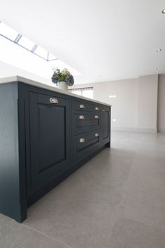 a large kitchen island in the middle of a room with white walls and flooring