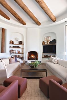 a living room filled with furniture and a fire place in the middle of a room