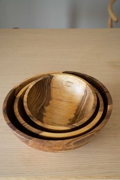 three wooden bowls sitting on top of a table