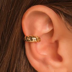 a woman's ear with a gold ring on it