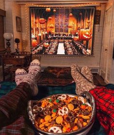 a person laying down with their feet up in front of a large bowl of food