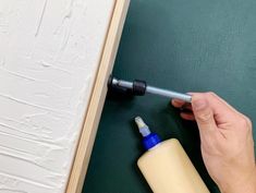 a person using a screwdriver to fix a wall