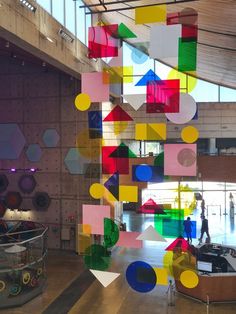 an art installation in a large building with lots of colorful objects hanging from the ceiling