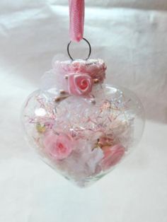 a glass ornament with pink roses in it