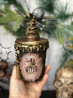 a hand is holding up a witch jar