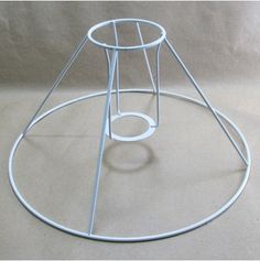 a white metal stand with two circles on it's sides and one circle at the top