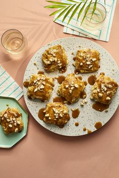 a white plate topped with cookies next to a glass of water and napkins on top of a table