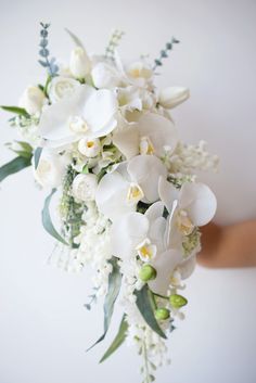 a bridal bouquet with white flowers and greenery