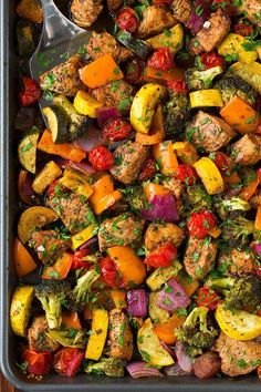 a pan filled with vegetables and meat on top of a wooden table