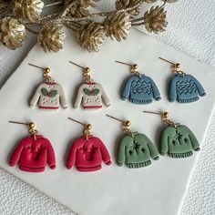 six pairs of earrings with sweaters on them