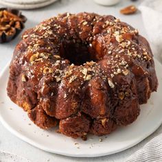 a bundt cake on a white plate topped with nuts