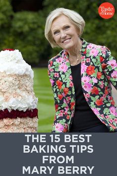 a woman standing next to a large cake on top of a green grass covered field