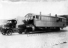 an old black and white photo of a train car being towed by a tow truck