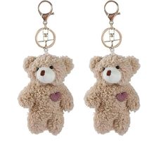 a teddy bear keychain hanging from a pair of keysets on a white background