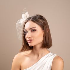 a woman wearing a white veil with a flower on the top and a birdcage over her head