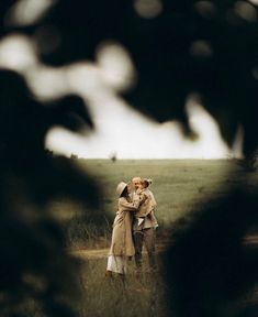 two people standing in the middle of a field