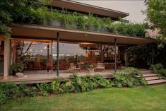 a house that has some plants growing on the roof and stairs in front of it