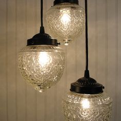 two glass lamps hanging from a ceiling