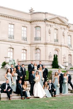 a large group of people in formal wear posing for a photo on the steps of a building