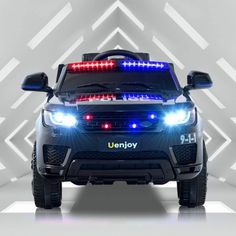 a police car with its lights on in front of a white and gray background,