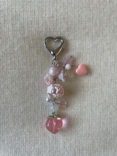 a key chain with hearts and beads hanging from it's side on a white surface