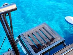 there is a surfboard sitting on the deck of a boat in the blue water