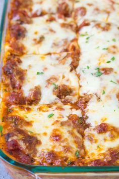 a green casserole dish filled with meat and cheese